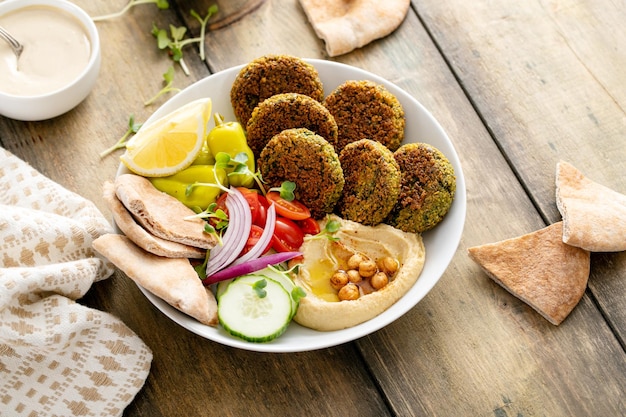 Foto gebackene falafel-schüssel mit hummus und gemüse