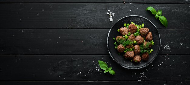 Gebackene Fleischbällchen mit Zwiebeln auf einer schwarzen Platte Draufsicht Freier Kopienraum