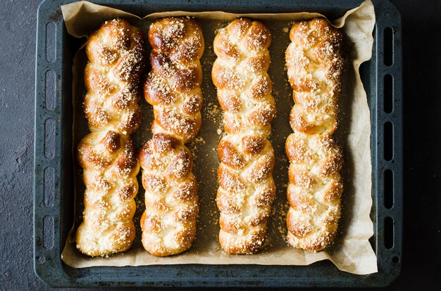 Gebackene frische duftende Brötchen. Traditionelles hausgemachtes Gebäck. Draufsicht der Zopfbrötchen.