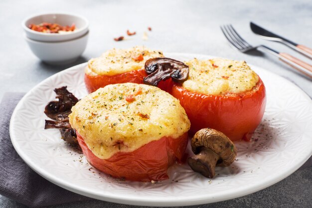 Gebackene ganze Tomaten gefüllt mit Champignons und Käse mit Gewürzen. Close up Tiefenschärfe
