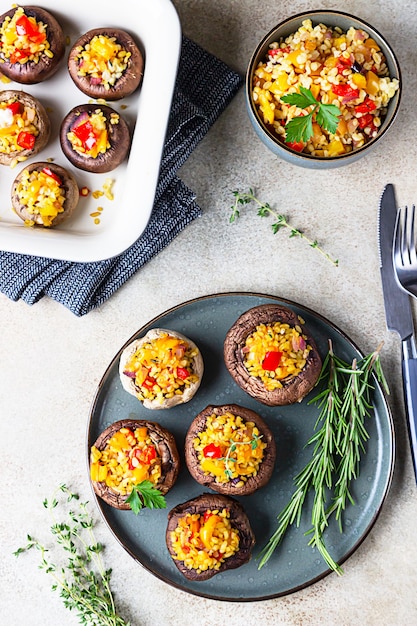 Gebackene gefüllte Portobello-Pilze mit Bulgur-Pilaw und gehacktem Gemüse.