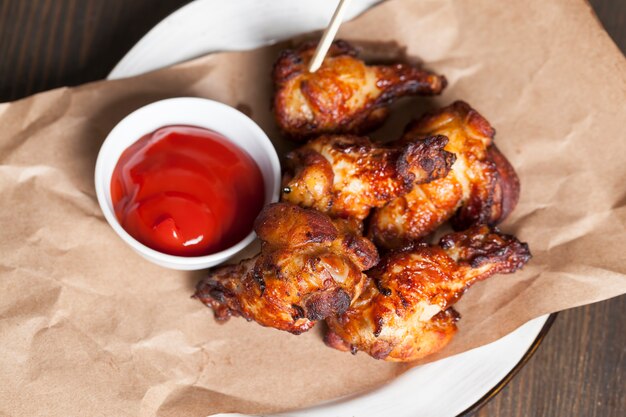 Gebackene Hähnchenflügel zusammen mit Ketchup