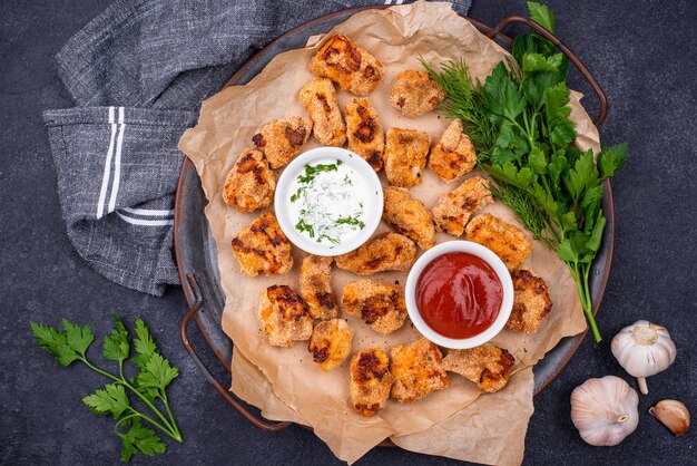 Gebackene Hühnernuggets mit Saucen und Gemüse