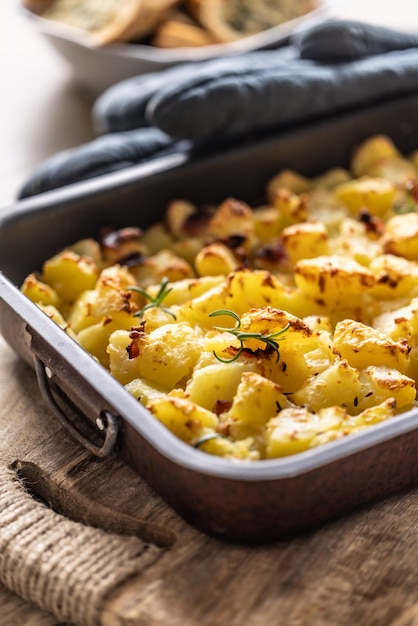 Gebackene knusprige Kartoffeln mit Rosmarin in einer alten Backschüssel