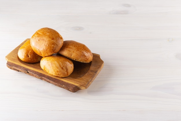 Gebackene Kuchen in einer Holzplatte auf einem weißen Tisch mit horizontaler Ausrichtung Kopienraum