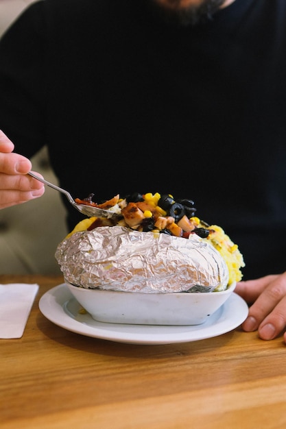 Gebackene Kumpirkartoffel gefüllt mit Käse, Wurst, Oliven, Paprika und Mais