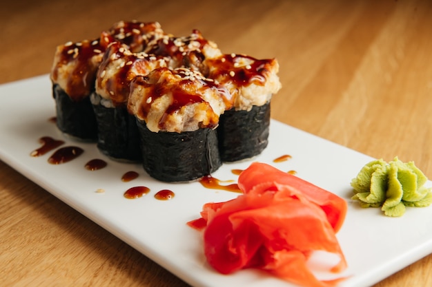 Gebackene Rolle mit Garnelen- und Masago-Kaviarkappe. Traditionelles Sushi-Restaurantgericht, Menüpunkt.