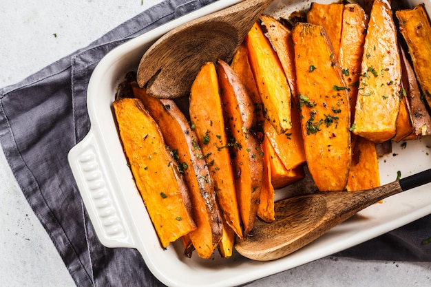 Gebackene Süßkartoffelscheiben mit Gewürzen im Ofenteller. Gesundes veganes Lebensmittelkonzept.