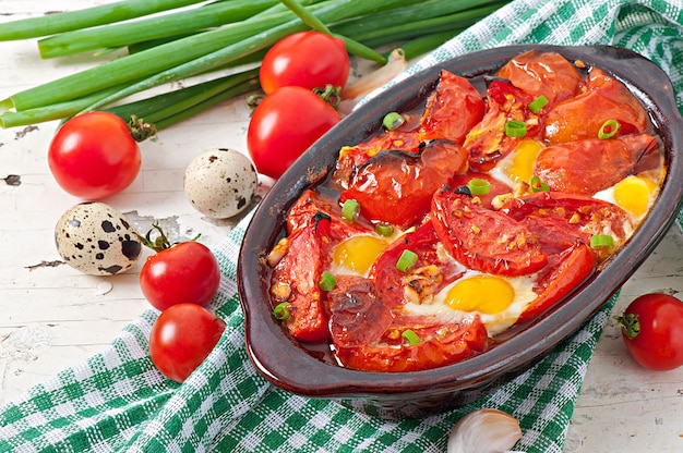 Gebackene Tomaten mit Knoblauch und Eiern mit Frühlingszwiebeln dekoriert