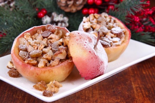 Foto gebackene weihnachtsäpfel mit nüssen und rosinen auf dem tisch hautnah