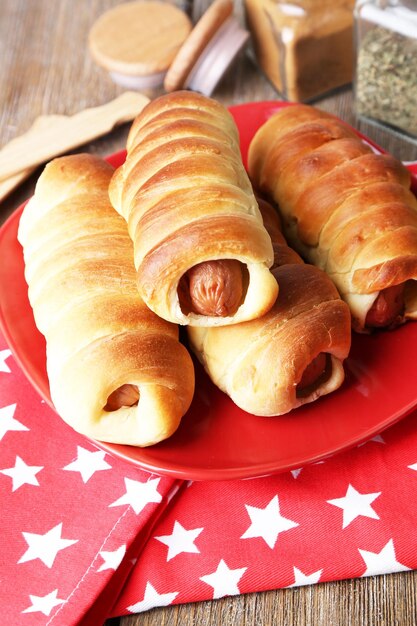 Gebackene Wurstbrötchen auf dem Teller auf dem Tisch in der Nähe