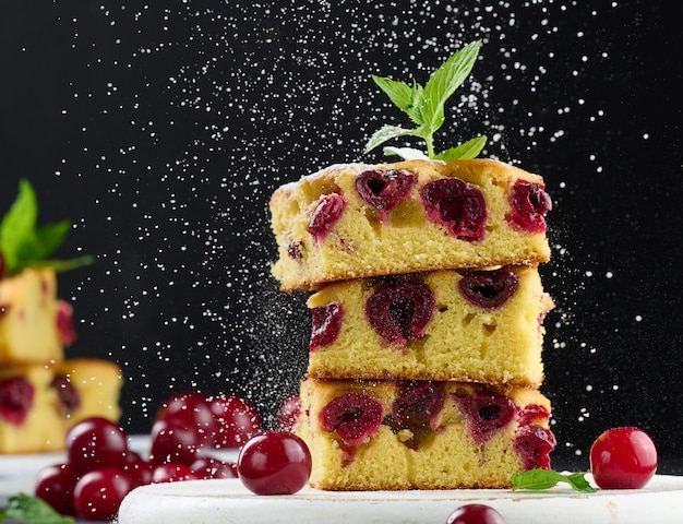 Gebackener Biskuitkuchen mit Kirschen bestreut mit Puderzucker