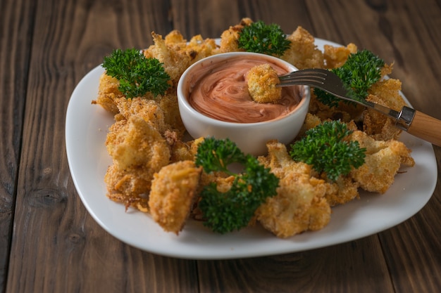 Gebackener Blumenkohl in einer weißen Schüssel mit Ketchup und Mayonnaise-Sauce. Vegetarische Blumenkohl Vorspeise.