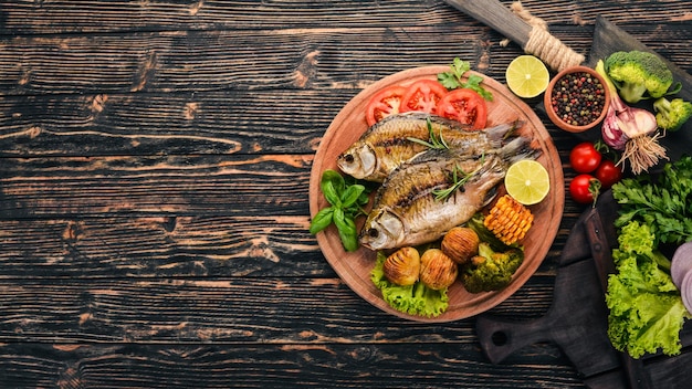 Gebackener Fisch mit Gewürzen und Gemüse Karpfen Auf einem hölzernen Hintergrund Ansicht von oben Kopieren Sie Platz