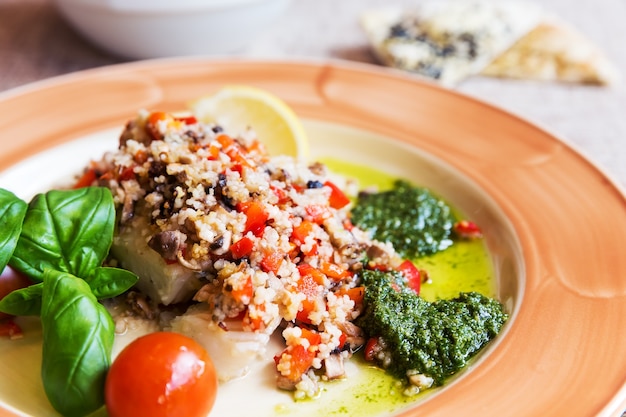 Foto gebackener heilbutt mit gemüsebeilage und couscous