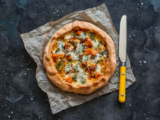 Gebackener Honigkürbis und Gorgonzola-Quiche auf dunklem Hintergrund Draufsicht Köstliches saisonales Gebäck