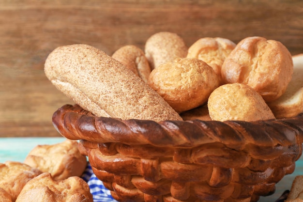 Gebackener Korb mit frischem Brot auf hölzern Hintergrund