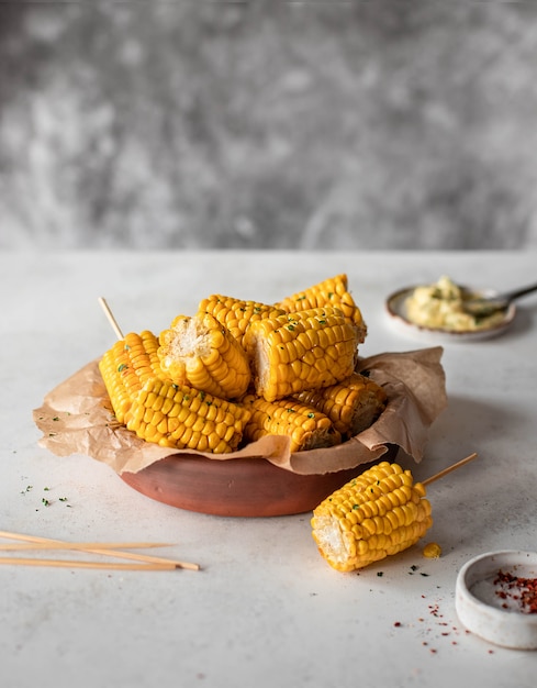 gebackener Mais mit Knoblauchbutter auf einem grauen Hintergrund