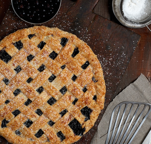 Gebackener runder Kuchen der Schwarzen Johannisbeere und mit Puderzucker pulverisiert