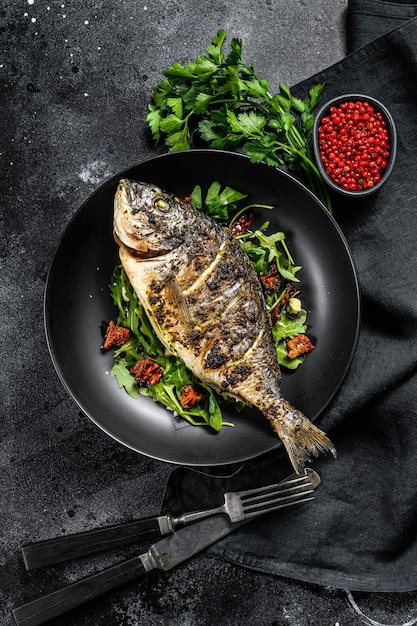 Gebackener Seebrassenfisch mit Rucola-Salat und Tomaten