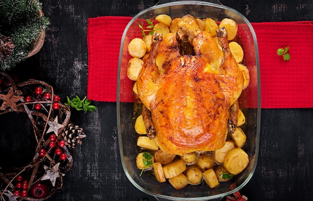 Gebackener Truthahn oder Huhn Der Weihnachtstisch wird mit einem mit hellen Schmuck geschmückten Truthahn serviert.