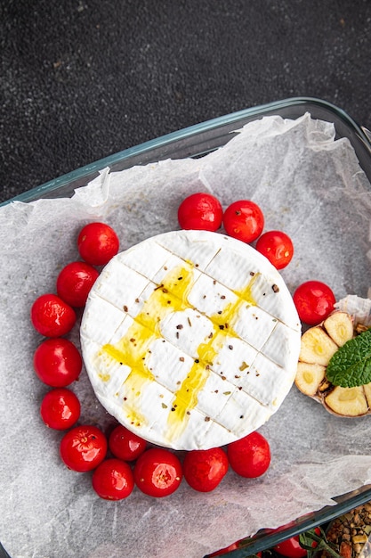 Gebackener Weichkäse Brie oder Camembert Tomate Knoblauch und Kräuter Mahlzeit Snack auf dem Tisch