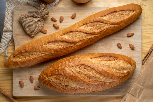 Gebackenes Baguette und Mehrkornbrot auf braunem Holztisch servierfertig.