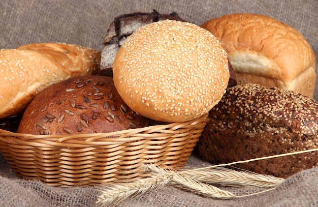 Gebackenes Brot im Weidenkorb auf Sackleinenhintergrund