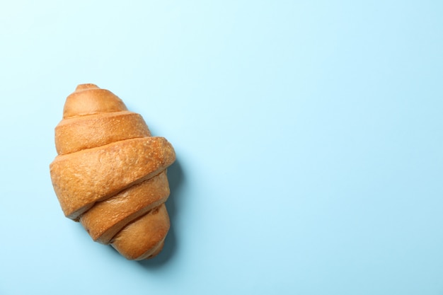 Gebackenes croissant auf blauem hintergrund, draufsicht