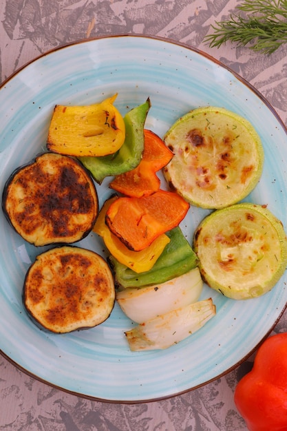 Gebackenes Gemüse Auberginen Paprika Zwiebeln Zucchini Gurken Pilze auf einem Teller Fotogerichte