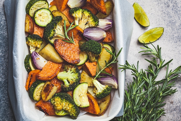 Gebackenes Gemüse in der Auflaufform, Draufsicht. Gegrillte Süßkartoffeln, Zucchini und Brokkoli. Gesundes veganes Lebensmittelkonzept.