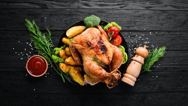 Gebackenes Hähnchen mit Kartoffeln und Gemüse auf schwarzem Hintergrund Das traditionelle Gericht für Thanksgiving Draufsicht Freier Kopierplatz