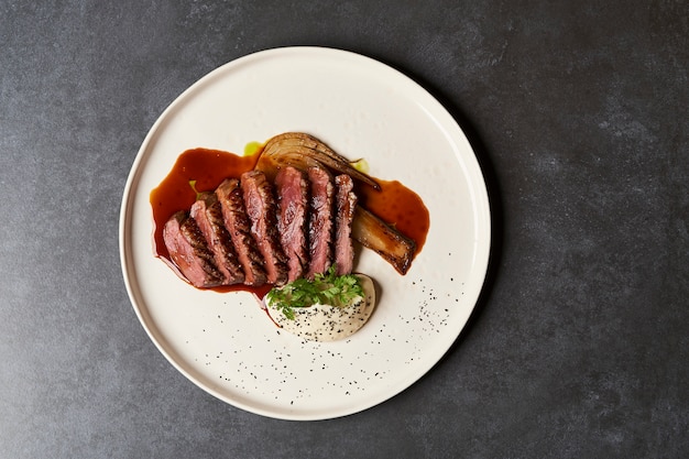 Gebackenes Hähnchenfilet mit Selleriepüree und Sauce auf weißem Teller