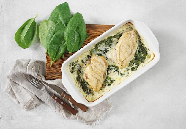 Gebackenes Hähnchenfilet mit Spinat in Sahnesauce in einer Pfanne auf dem Kopierraum der Tischplatte