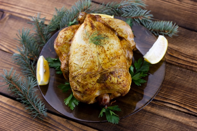 Gebackenes Huhn auf Holztisch. Festliches Mittagessen für die Feiertage. Gekochtes Hähnchen zu Hause