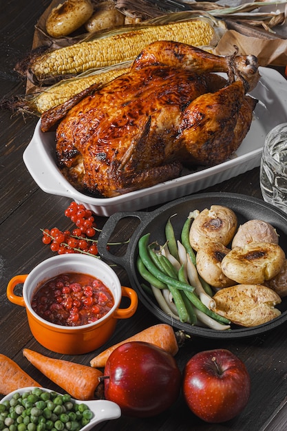 Gebackenes Huhn und gebackener Mais. Familienessen Tisch. gebackenes Huhn und Gemüse mit Gläsern Apfelwein. leckeres rustikales Abendessen