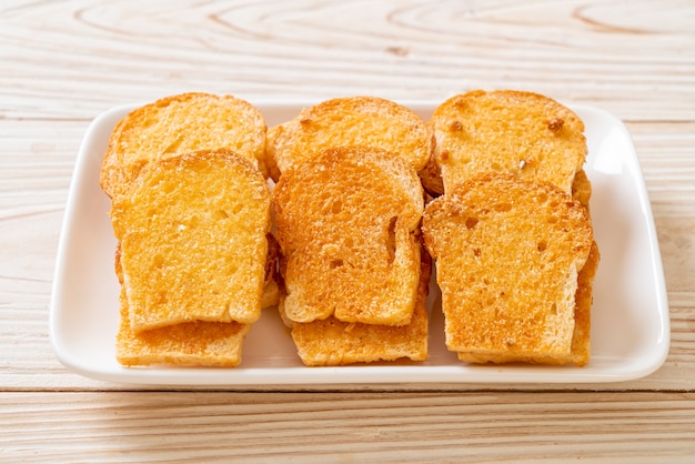 gebackenes knuspriges Brot mit Butter und Zucker auf Teller