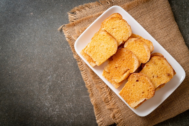 gebackenes knuspriges Brot mit Butter und Zucker auf Teller