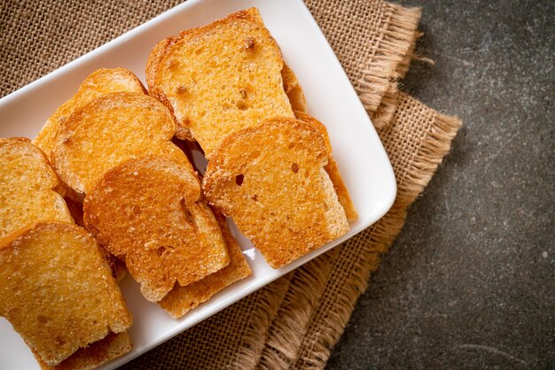 gebackenes knuspriges Brot mit Butter und Zucker auf Teller