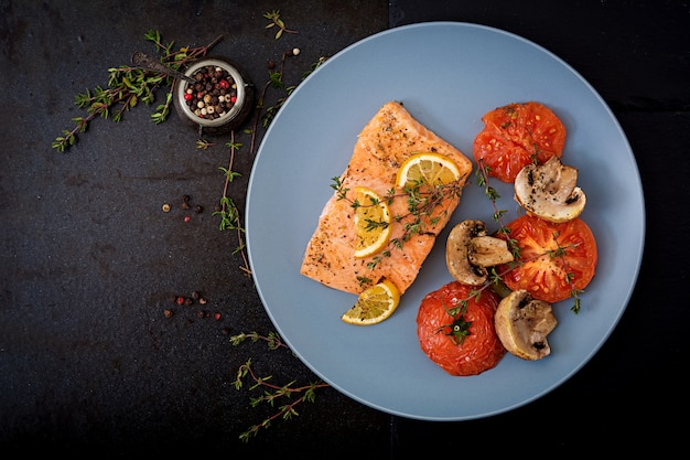 Gebackenes Lachsfilet mit Tomaten, Pilzen und Gewürzen. Diät-Menü.