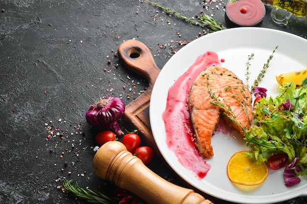 Gebackenes Lachssteak und frisches Gemüse auf einem Teller Draufsicht Freier Kopierplatz