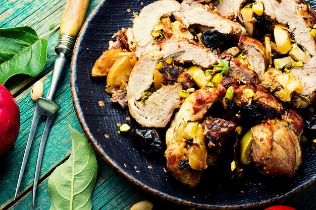 Gebackenes Schweinefleisch mit Datteln, Äpfeln und Pistazien. Gebratenes mageres Schweinefleisch. Gefüllte Schweinerolle