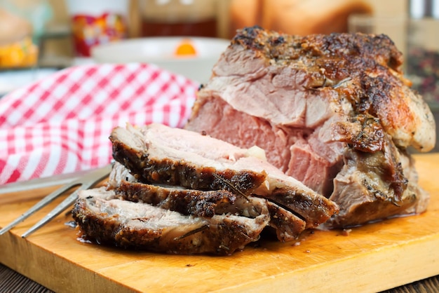 Gebackenes Schweinefleisch mit Gewürzen auf braunem Holzschneidebrett