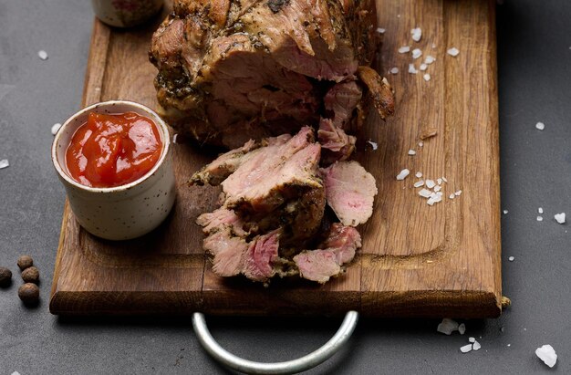 Gebackenes Schweinehalsband mit Gewürzen auf einem Holzbrett köstliches und saftiges Fleisch