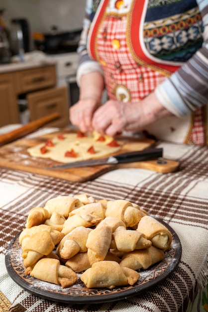 Gebäck- und Backkonzept. Frau, die hausgemachte Brötchen mit Marmelade zu Hause vorbereitet