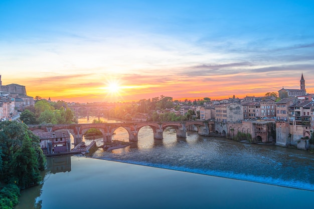 Gebäude am Fluss gegen den Himmel beim Sonnenuntergang