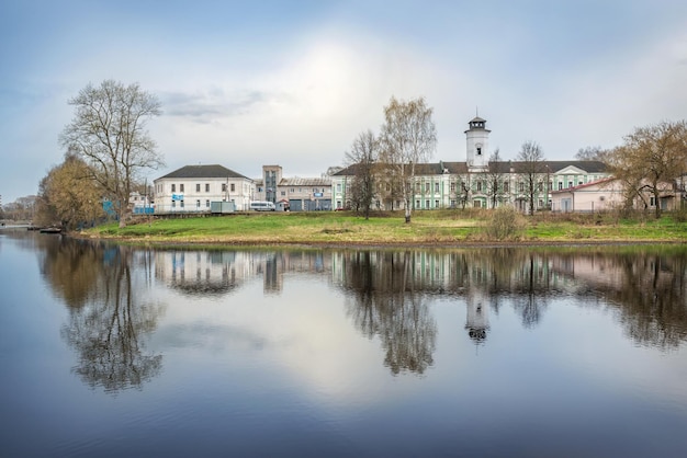 Gebäude der Feuerwache mit Reflexion im Wasser in Vyshny Volochyok und dem Fluss Tsna