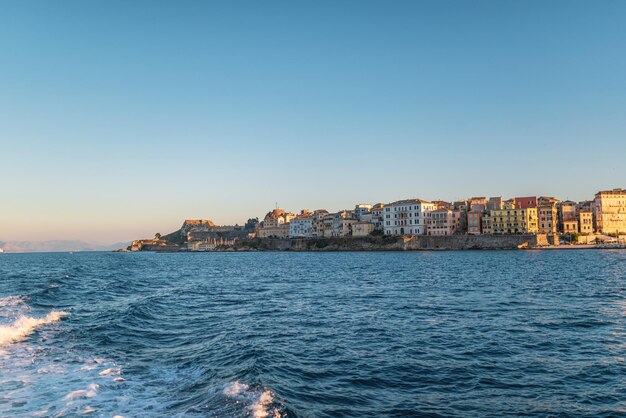 Gebäude der Insel Korfu am Ufer und Meerwasser bei Sonnenuntergang