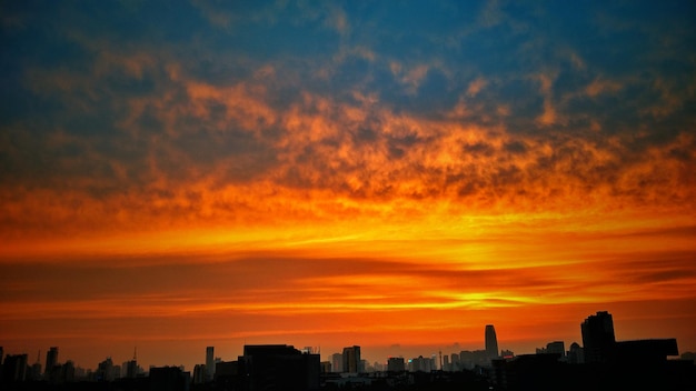 Gebäude gegen wolkenfarbenen orangefarbenen Himmel beim Sonnenuntergang