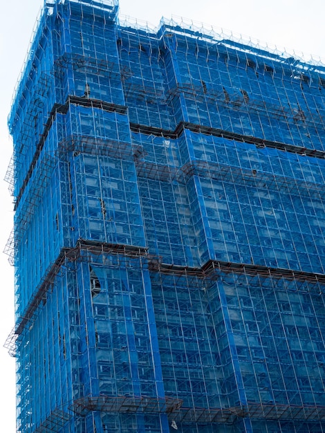 Gebäude im Bau eingewickeltes blaues Schutzsicherheitsnetz